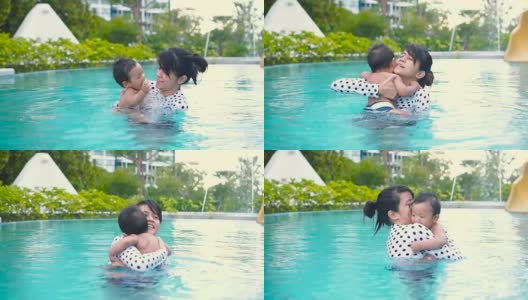 年轻的母亲教儿子如何在游泳池游泳。/泰国。高清在线视频素材下载