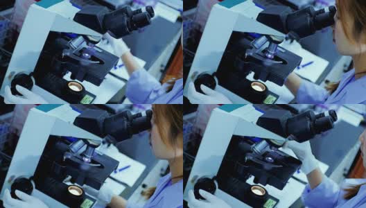 在实验室里透过显微镜看东西的女科学家高清在线视频素材下载