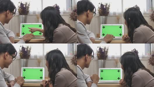 两个人在看绿色屏幕的笔记本电脑高清在线视频素材下载