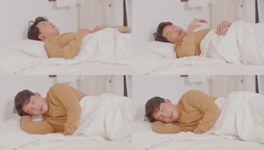 英俊迷人的亚洲男人睡觉和甜蜜的梦躺在床上舒适的卧室早上感觉如此放松和舒适。健康的年轻男性在家就寝。医疗保健的概念高清在线视频素材下载