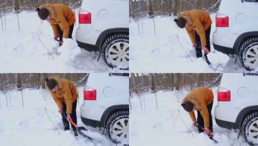 男子用铲车铲在雪地里挖出一辆熄火的汽车。冬天一场大雪过后，交通被困在了雪堆里，坐到了底部。急救，拖车，冬季轮胎钉和四季。慢动作高清在线视频素材下载