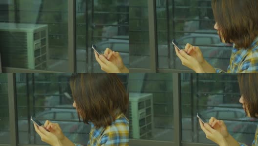 女士用手机看外面的雨。侧视图。从右到左。高清在线视频素材下载