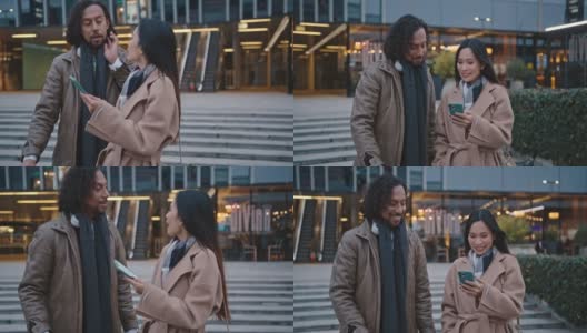 一对拉美裔和亚裔夫妇在商场前用智能手机高清在线视频素材下载