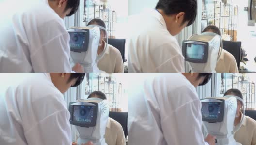 亚洲年轻女子在眼科医生的办公室被专业设备检查她的视力，由电脑监控，准备制作光学眼镜，看后肩高清在线视频素材下载