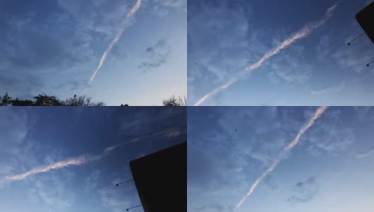 黎明时分，一架飞机在美丽的多云天空上划过尾迹高清在线视频素材下载