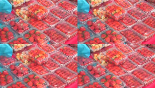 农贸市场的柜台上出售塑料盒装的新鲜有机草莓高清在线视频素材下载