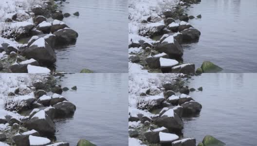 冬天河岸的岩石。大石头上有雪。高清在线视频素材下载