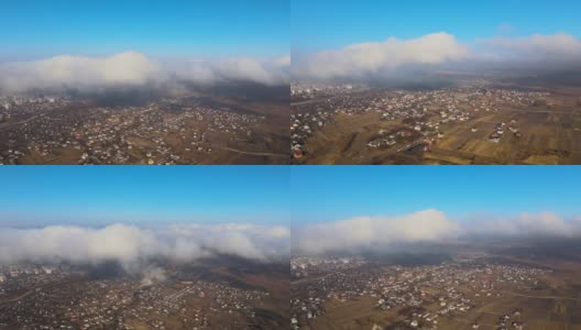 从高空俯瞰，在暴雨来临之前，蓬松的积云覆盖着遥远的城市。多云天气的飞机视角高清在线视频素材下载