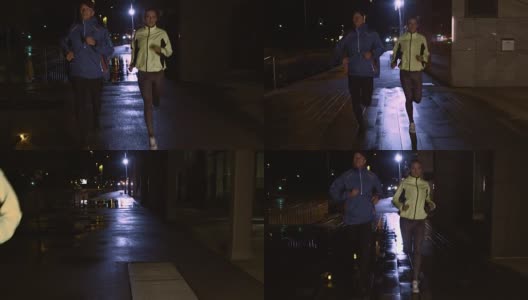 一对夫妇在雨夜的街道上慢跑高清在线视频素材下载