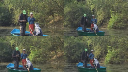 一对情侣在森林里的湖面上划着划艇，在划手的陪伴下自拍高清在线视频素材下载