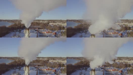 瑞典斯堪的那维亚一个阳光明媚的冬日里，发电厂的烟囱里冒着污染的浓烟发电高清在线视频素材下载