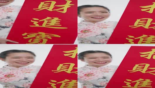 中国/亚洲妇女穿着旗袍，递上大的红色中国招牌，表示新年快乐，富裕，幸福和幸运高清在线视频素材下载