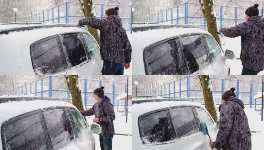 一名男子在雪后从车上刷雪。夹克里的一只手，白色的身体上放着一把汽车扫把。冬天的天气条件。慢动作高清在线视频素材下载