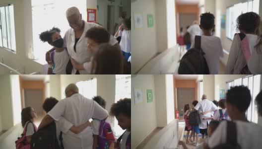小学生走在学校走廊上，拥抱老师高清在线视频素材下载