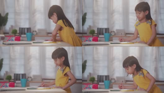亚洲女孩坐在家里的客厅里学习和画画高清在线视频素材下载