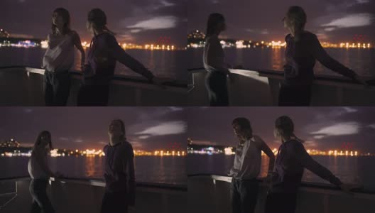 两个迷人的年轻女人的剪影在夜里在船上旅行。船上的闺蜜高清在线视频素材下载