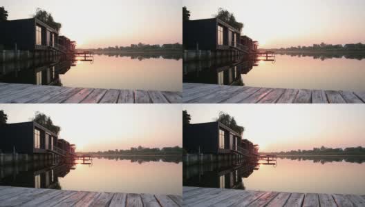 日出在河面附近的房屋高清在线视频素材下载