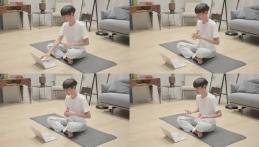 年轻的亚洲男子在瑜伽垫上使用笔记本电脑高清在线视频素材下载