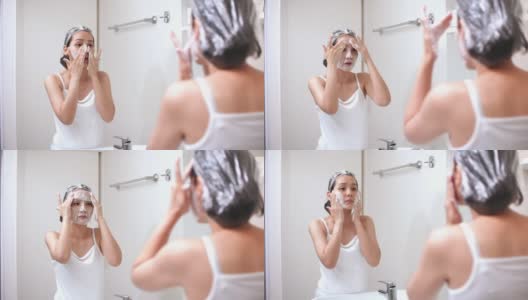 年轻的亚洲妇女在浴室里洗脸高清在线视频素材下载