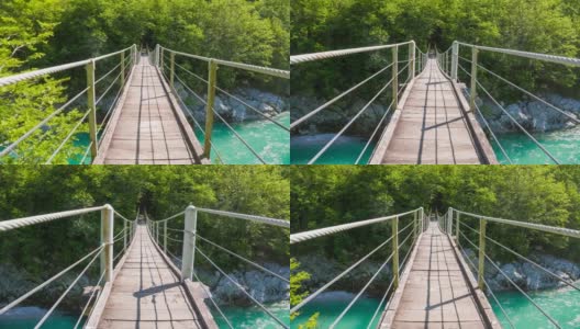 跨越木吊桥，横跨雄伟的绿松石河谷高清在线视频素材下载