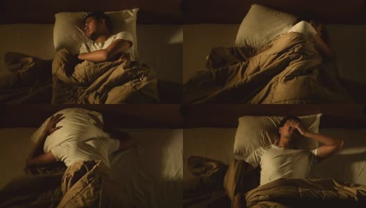 一名沮丧的男子因失眠躺在床上的画面高清在线视频素材下载