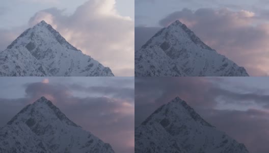 日落在雪山的山峰上，云朵在山峰后面生长高清在线视频素材下载