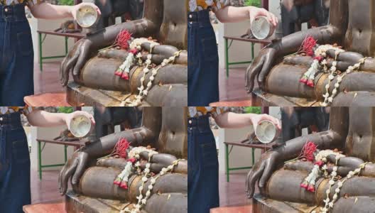 泰国泼水节期间，妇女用手向佛像泼香水。高清在线视频素材下载