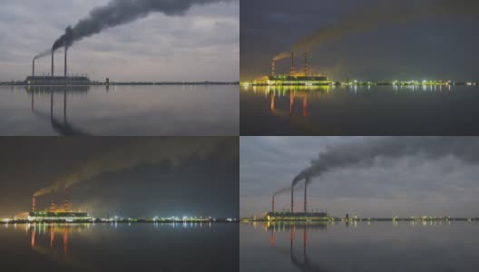 燃煤电厂的高管与黑烟快速移动污染大气在夜间与倒影在湖水。日到夜的时间推移过渡高清在线视频素材下载