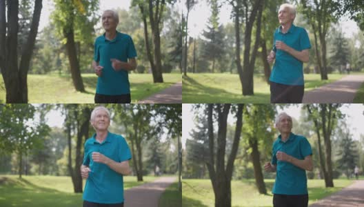 快乐的老人在户外的阳光下慢跑，环顾四周微笑。健康的白人退休运动员的肖像在夏季春天公园欣赏自然的慢动作跑步。生活方式和运动。高清在线视频素材下载