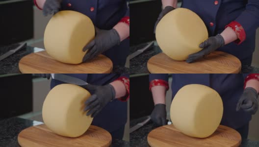 一名奶酪奶场工人正在检查煮熟的硬奶酪。销售前对产品质量进行评估。高清在线视频素材下载