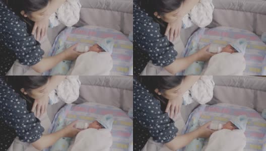 亚洲母亲喂婴儿的奶瓶男孩。高清在线视频素材下载