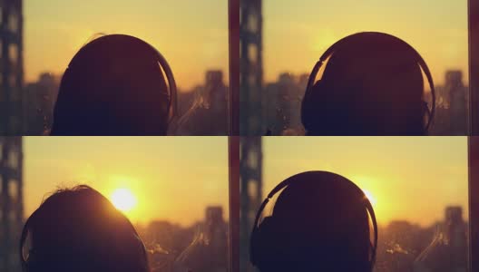迷人的年轻女子听音乐的音乐播放器在城市模糊的背景与日落享受音乐在她的耳机在缓慢的动作高清在线视频素材下载