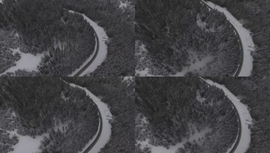 汽车行驶在雪地里的乡村道路上，无人机鸟瞰图高清在线视频素材下载