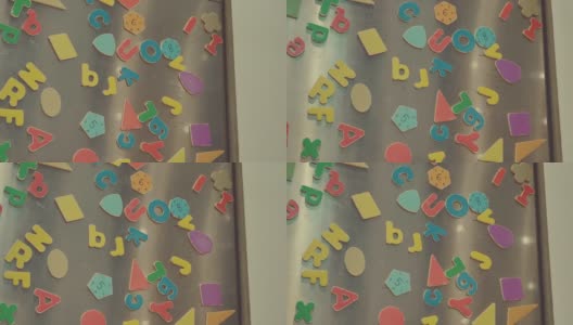 冰箱门上彩色磁铁的细节。由父母制作，儿子在家玩，家庭物品的概念高清在线视频素材下载
