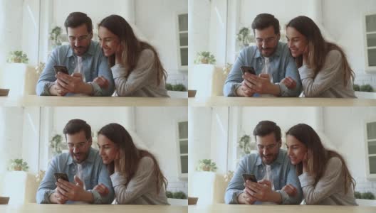 幸福的情侣使用智能手机玩手机游戏购物在应用程序高清在线视频素材下载
