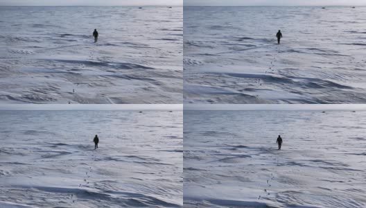 鸟瞰图:一个孤独的人走过雪地高清在线视频素材下载