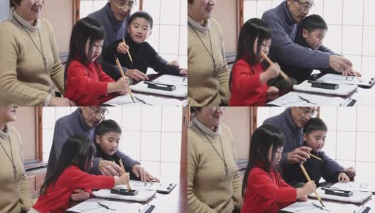 亚洲的祖父母和孙辈在练习书法高清在线视频素材下载