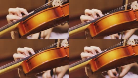 一个年轻的小提琴手模糊的左手按下小提琴颈上的弦，水平高清在线视频素材下载