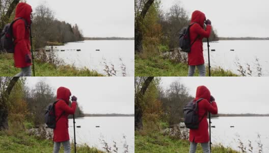 一名身穿红色夹克、背着双肩包的女子站在湖边，拍摄风景高清在线视频素材下载