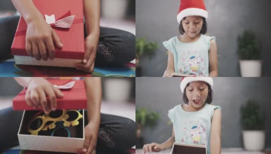 戴圣诞帽的女孩打开礼盒。高清在线视频素材下载