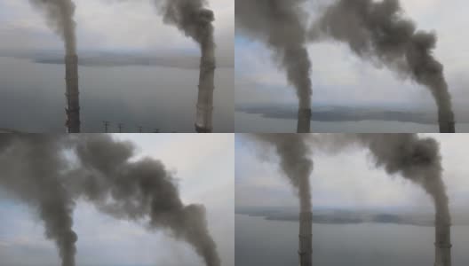 从空中俯瞰燃煤电厂高高的管道，黑烟在污染的大气中向上移动。高清在线视频素材下载