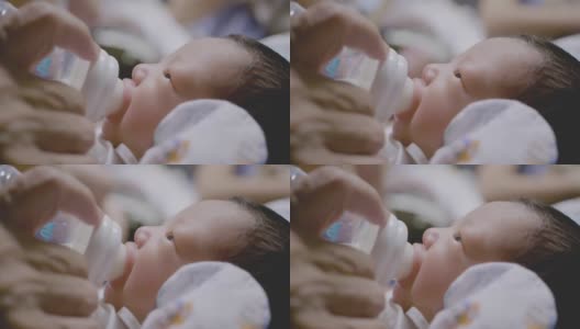 亚裔祖母用奶瓶喂新生儿。高清在线视频素材下载