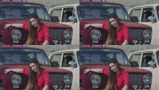 一位年轻女子以一辆旧车为背景摆好姿势高清在线视频素材下载