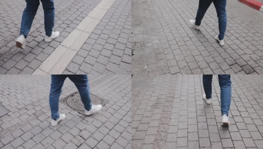 这是一个穿着白色运动鞋和牛仔裤的男子的腿部特写镜头，他自信地走在特拉维夫街头的人行道上。50帧/秒慢动作高清在线视频素材下载