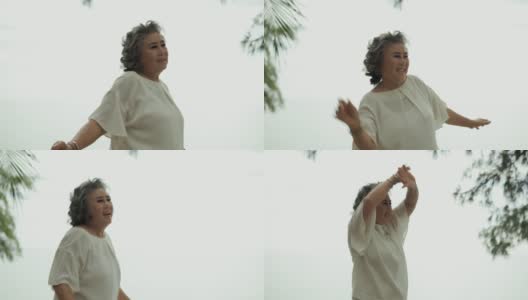 快乐的退休女老人在海滩上跳舞高清在线视频素材下载