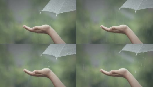 女人在雨中用手掌抓住雨滴高清在线视频素材下载