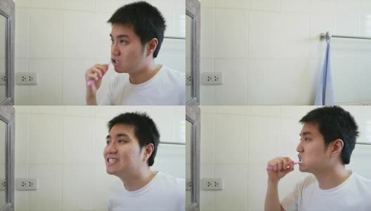 一名亚洲男子早上在浴室对着镜子刷牙高清在线视频素材下载