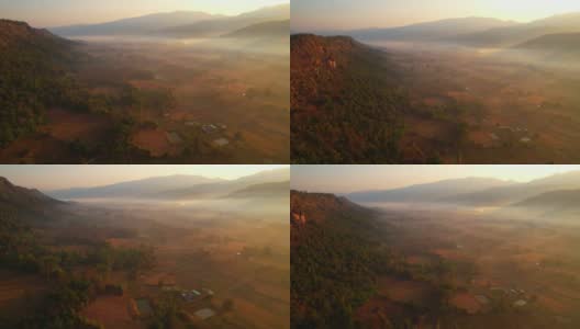 鸟瞰村庄和农村贫瘠的土地在日出，背景山。高清在线视频素材下载