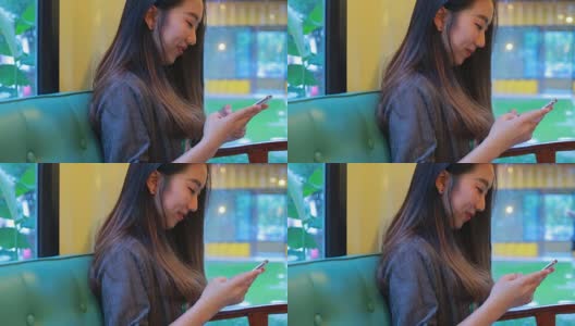 美丽的亚洲女孩在咖啡店打字手机高清在线视频素材下载
