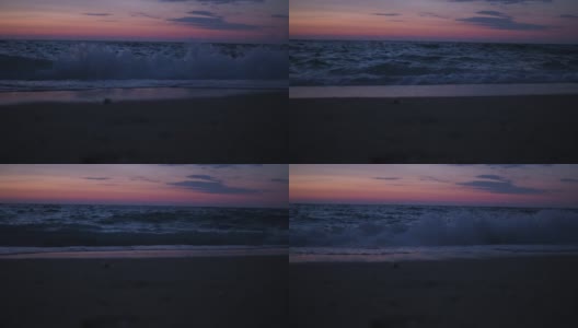 太阳落山后，人们在黄昏时到海里游泳。远处可以看到漂浮的人。在海边度假。日落高清在线视频素材下载